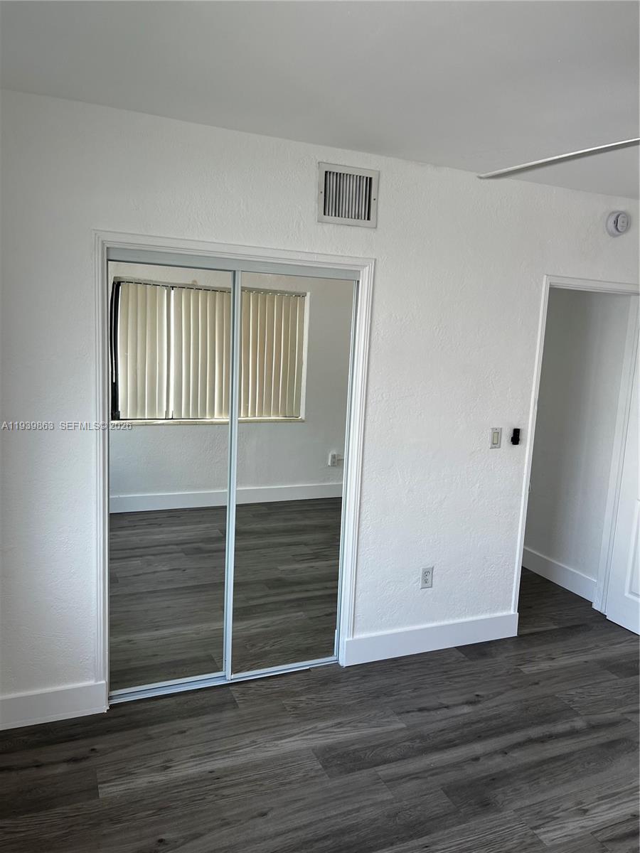 650 83rd Street, Unit 1 Miami Beach, FL 33141 - Photo 31 of 37 a view of an empty room with wooden floor and a window