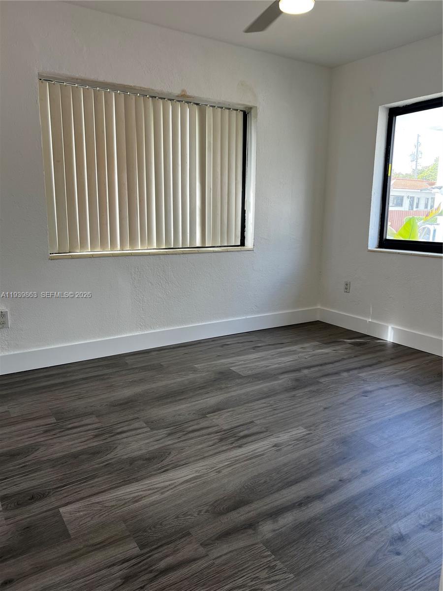 650 83rd Street, Unit 1 Miami Beach, FL 33141 - Photo 34 of 37 a view of an empty room with wooden floor and a window