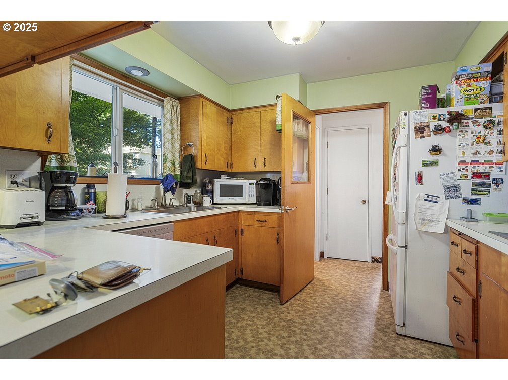 205 Northeast 160th Avenue Portland, OR 97230 - Photo 12 of 35 a kitchen that has a lot of cabinets a sink and a stove in it