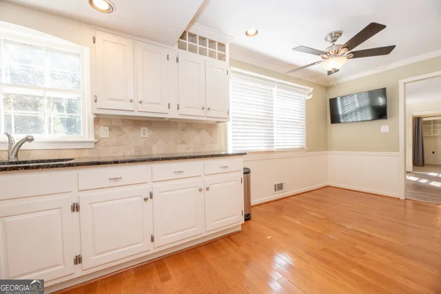 a kitchen with granite countertop white cabinets and white appliances