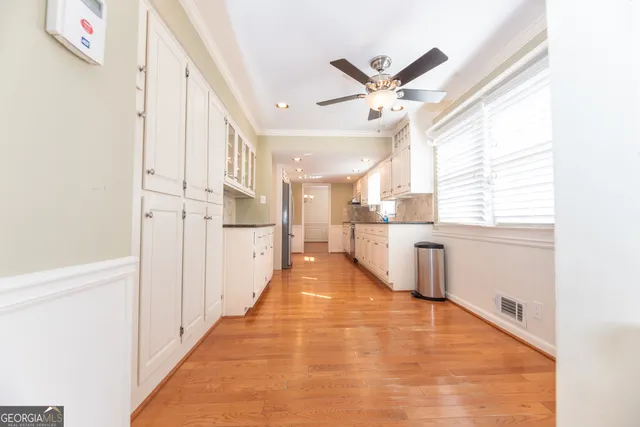 a view of a kitchen with a sink and dishwasher a refrigerator with wooden floor