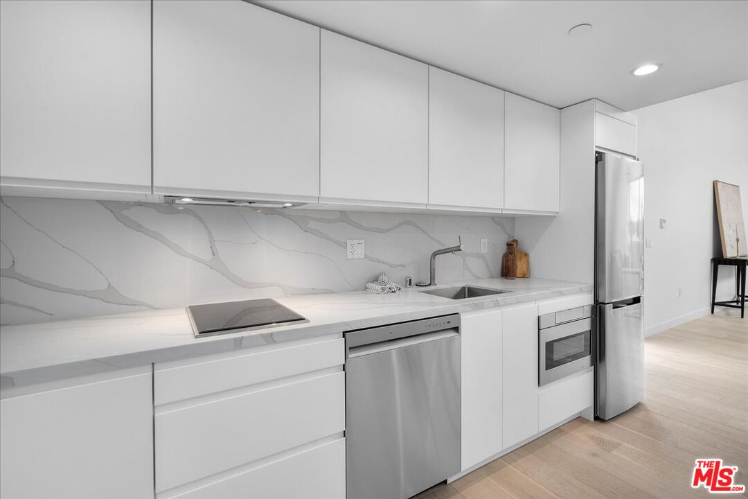 541 Rose Avenue, Unit LOFT Venice, CA 90291 - Photo 8 of 13 a kitchen with stainless steel appliances granite countertop white cabinets and a sink