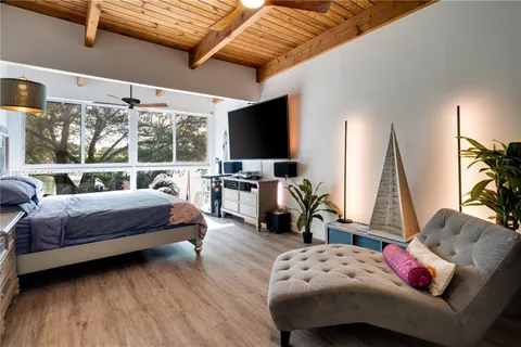 a bedroom with a bed and large windows