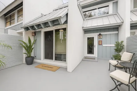 a view of a chair and table in the back yard of the house