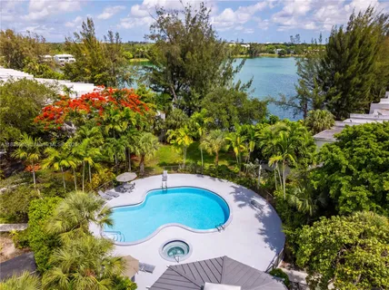 a view of a swimming pool with a yard and plants