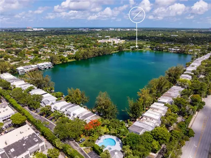 an aerial view of residential houses with outdoor space and lake view