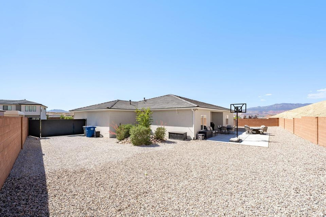 5963 Flattop Drive St. George, UT 84790 - Photo 41 of 45 Expansive gravel yard featuring a rear concrete patio, stucco exterior, and a privacy wall