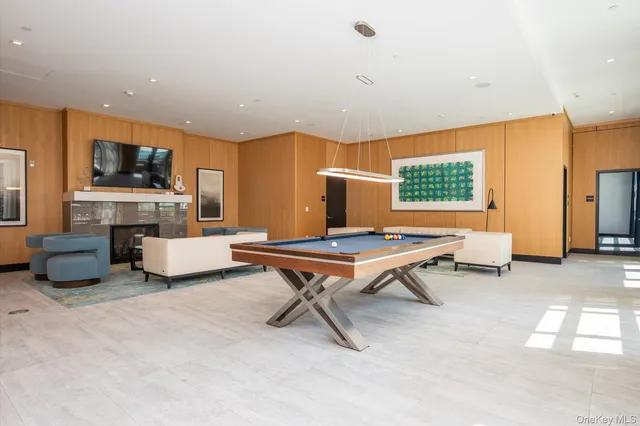 a living room with furniture a flat screen tv and kitchen view