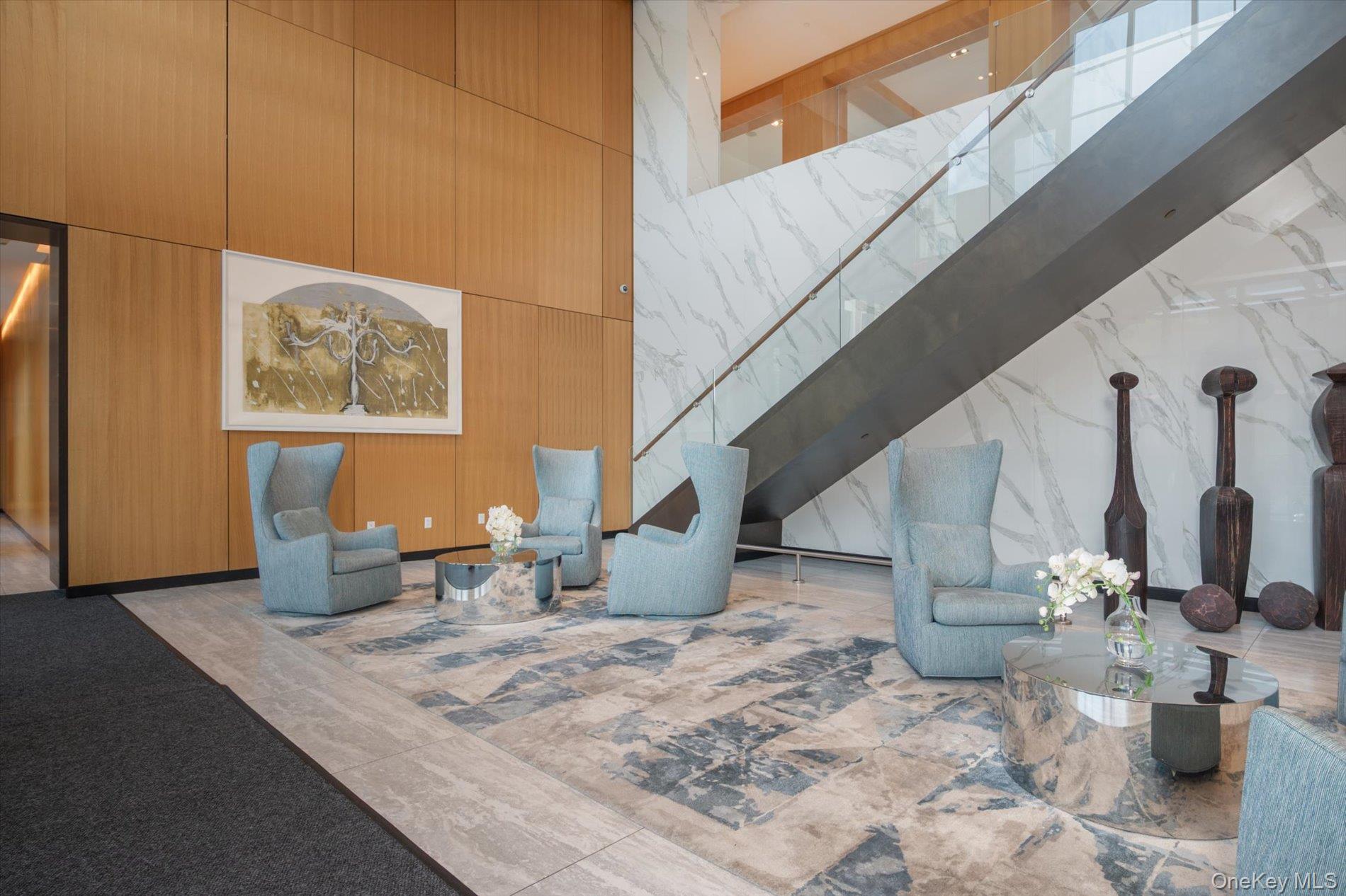 100 Garvies Point Road, Unit 1042 Glen Cove, NY 11542 - Photo 25 of 33 Building lobby featuring a high ceiling and stairway