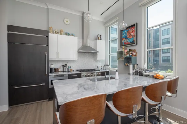 a kitchen with stainless steel appliances granite countertop a refrigerator a sink and a stove