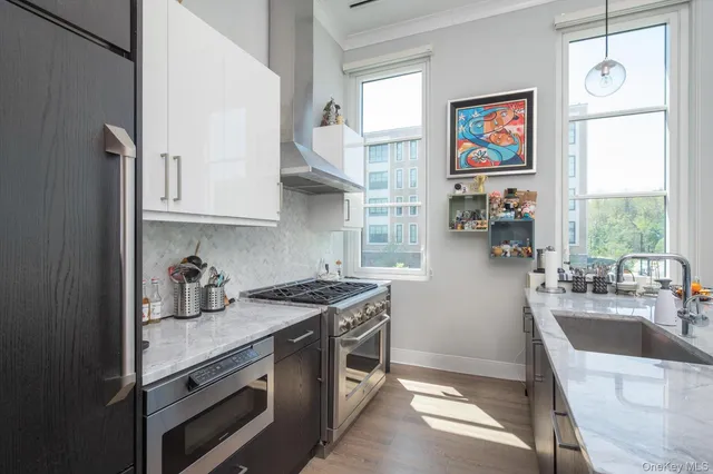 a kitchen with stainless steel appliances granite countertop a stove a sink and a refrigerator