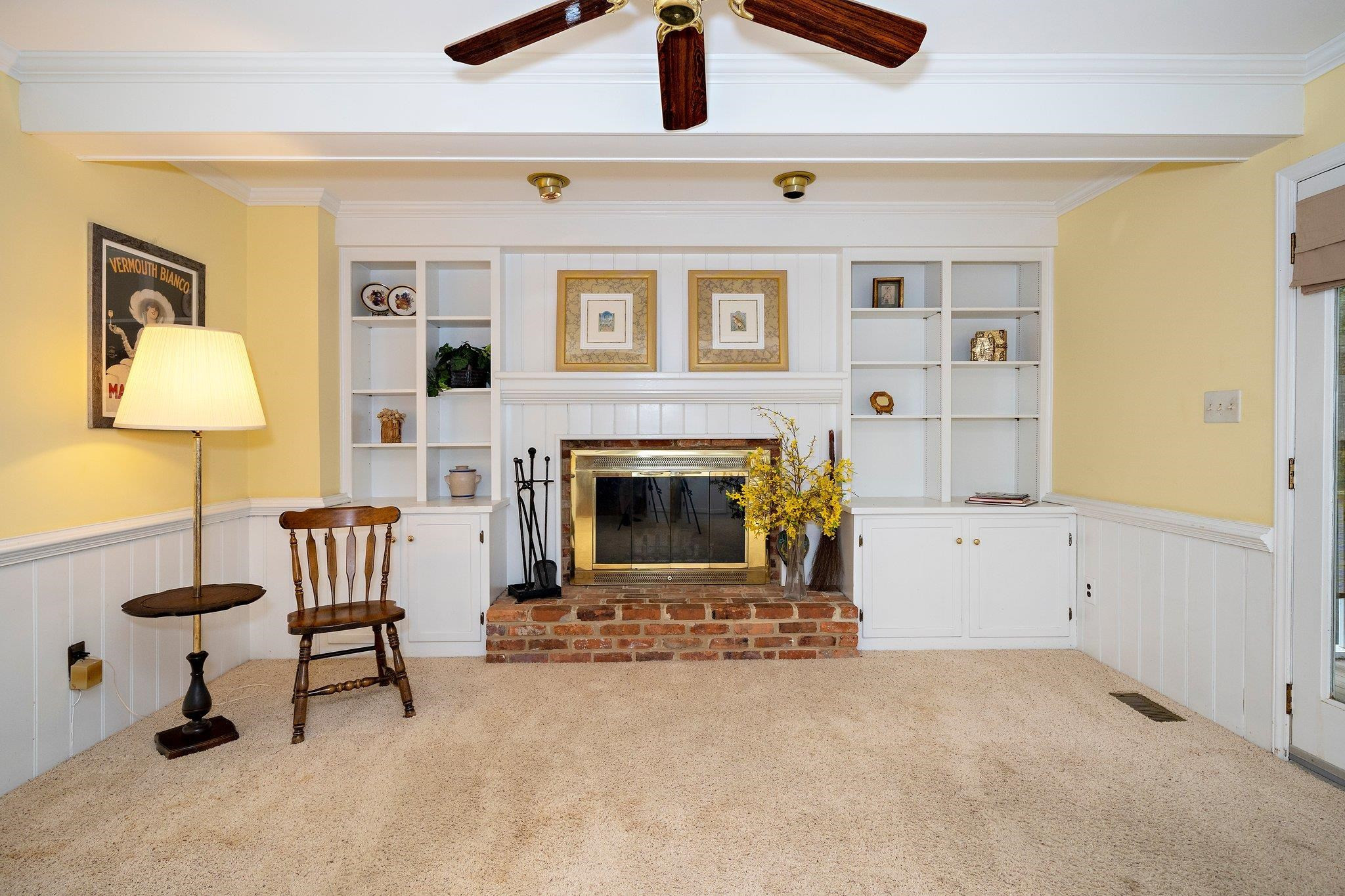 1512 Pony Run Road Raleigh, NC 27615 - Photo 4 of 39 Family Room has Wood-burning Fireplace flanked by Built-in Bookshelves & Cabinetry, Wainscoting Plus Smooth Ceiling with Beams and Ceiling Fan Family Room