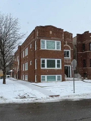a front view of a building with a snow on the road