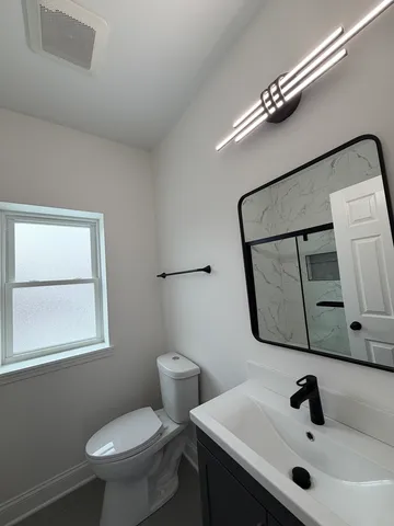 a bathroom with a sink mirror and toilet