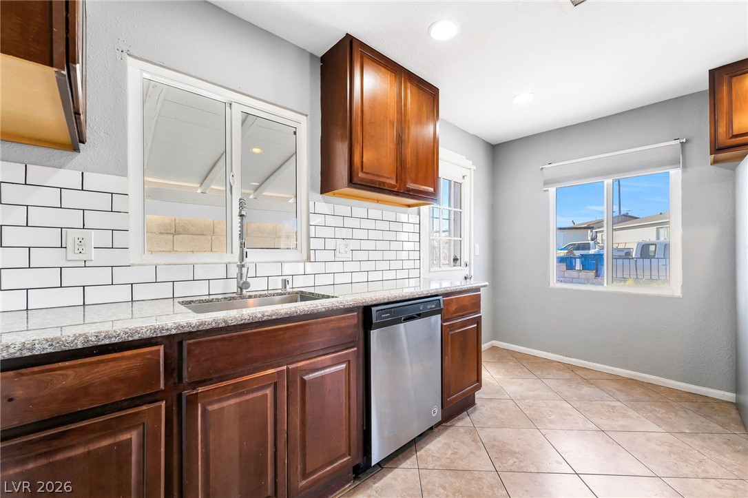 140 West Victory Road Henderson, NV 89015 - Photo 16 of 24 A streamlined kitchen design showcases rich cabinetry, granite countertops, and modern appliances.