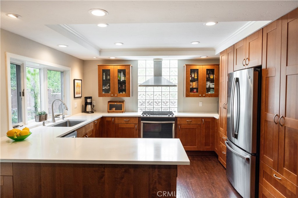 26251 Brookhollow Lake Forest, CA 92630 - Photo 6 of 27 a kitchen with a refrigerator a sink and wooden cabinets