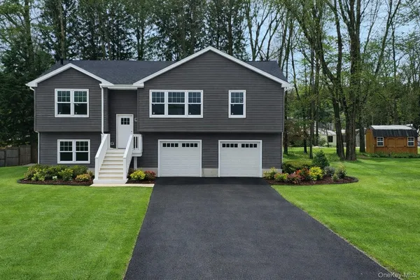 a front view of a house with a garden and yard