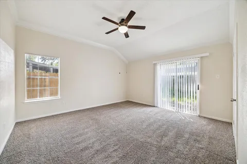 an empty room with windows and ceiling fan