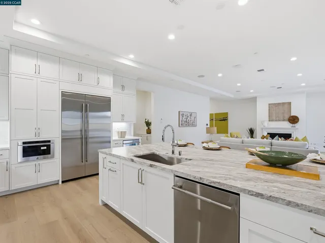 a kitchen with stainless steel appliances granite countertop white cabinets a sink and dishwasher
