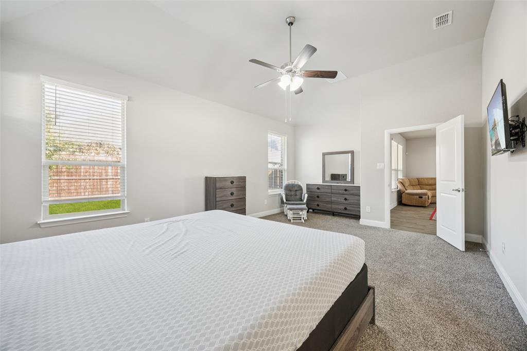11520 Lavonia Road Fort Worth, TX 76244 - Photo 13 of 32 a spacious bedroom with a large bed and flat screen tv