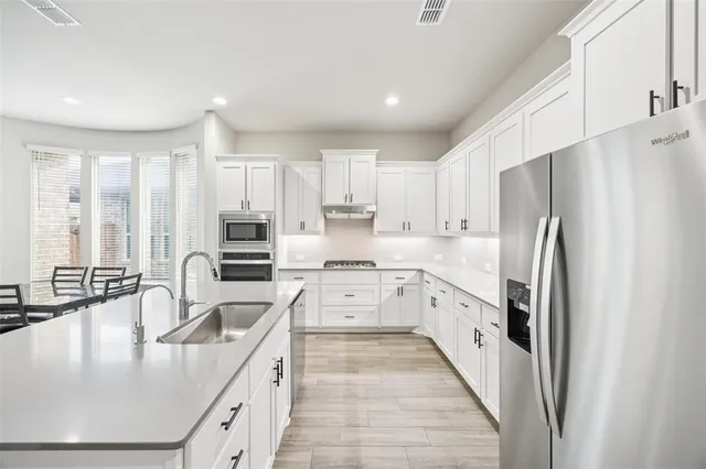 a kitchen with stainless steel appliances granite countertop a sink stove and refrigerator