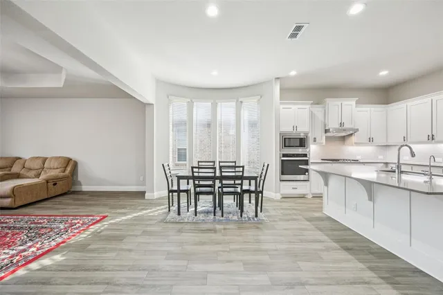 a dining room with furniture and wooden floor