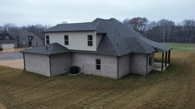 an empty room with a chandelier fan and windows