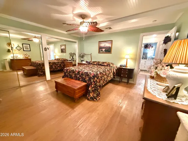 a spacious bedroom with a bed and wooden floor