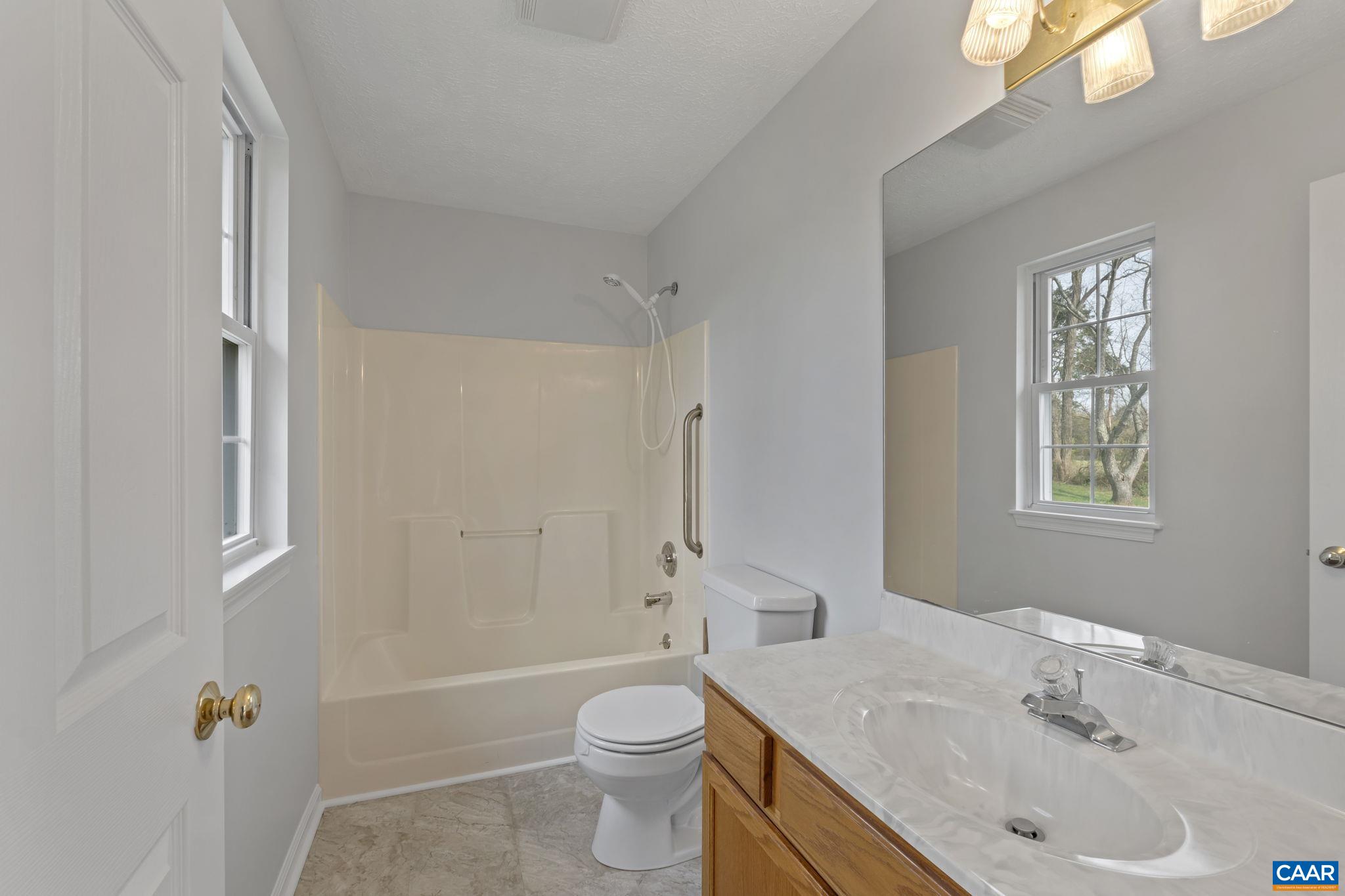 255 Rustling Oaks Way Ruckersville, VA 22968 - Photo 14 of 18 a bathroom with a sink toilet and shower