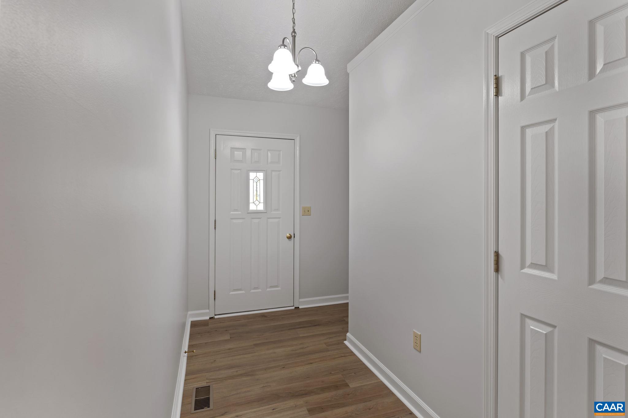 255 Rustling Oaks Way Ruckersville, VA 22968 - Photo 5 of 18 a view of a hallway with wooden floor and closet
