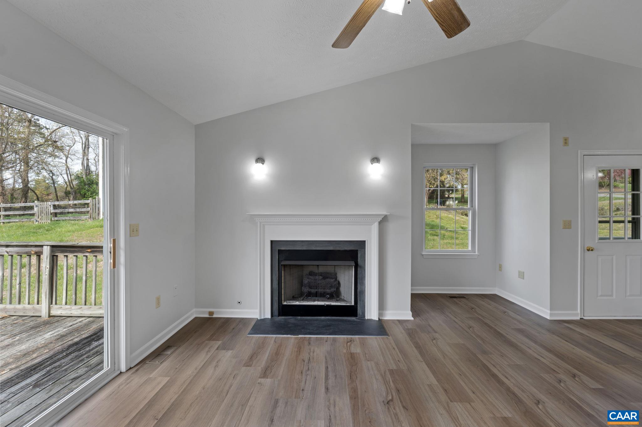 255 Rustling Oaks Way Ruckersville, VA 22968 - Photo 7 of 18 an empty room with wooden floor fireplace and windows