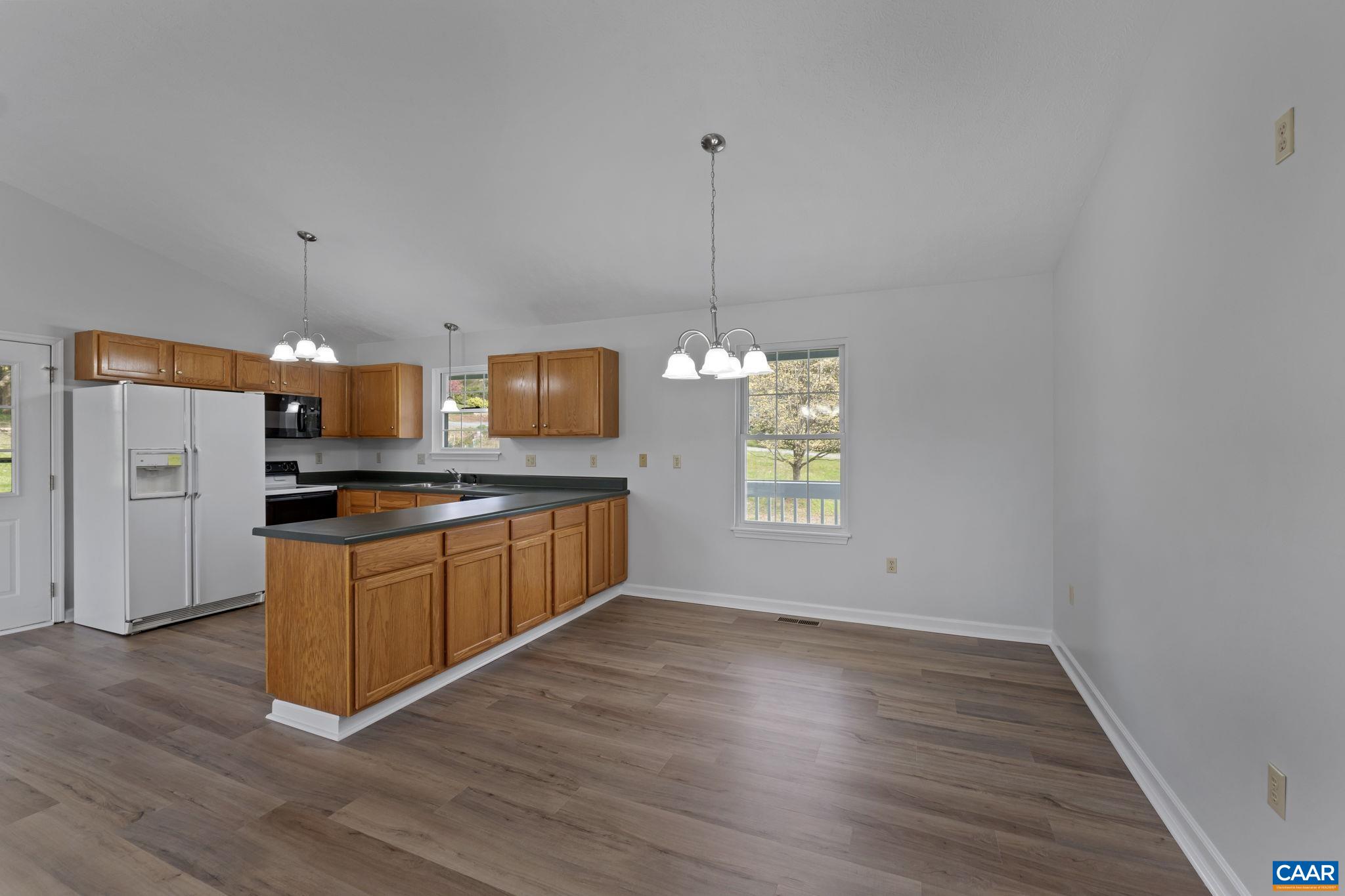 255 Rustling Oaks Way Ruckersville, VA 22968 - Photo 8 of 18 a kitchen with stainless steel appliances granite countertop a sink a refrigerator a stove a microwave and island with wooden floor