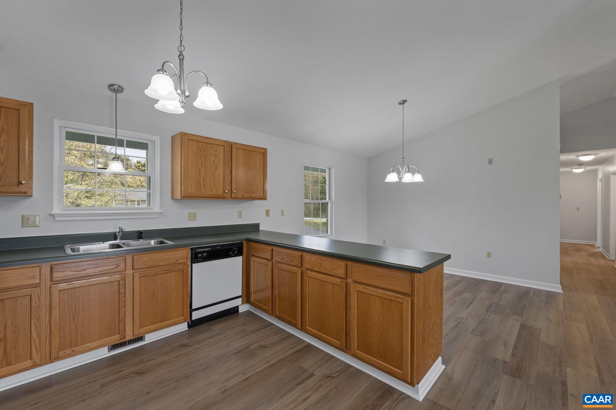 255 Rustling Oaks Way Ruckersville, VA 22968 - Photo 9 of 18 a kitchen with stainless steel appliances granite countertop wooden floors wooden cabinets and sink