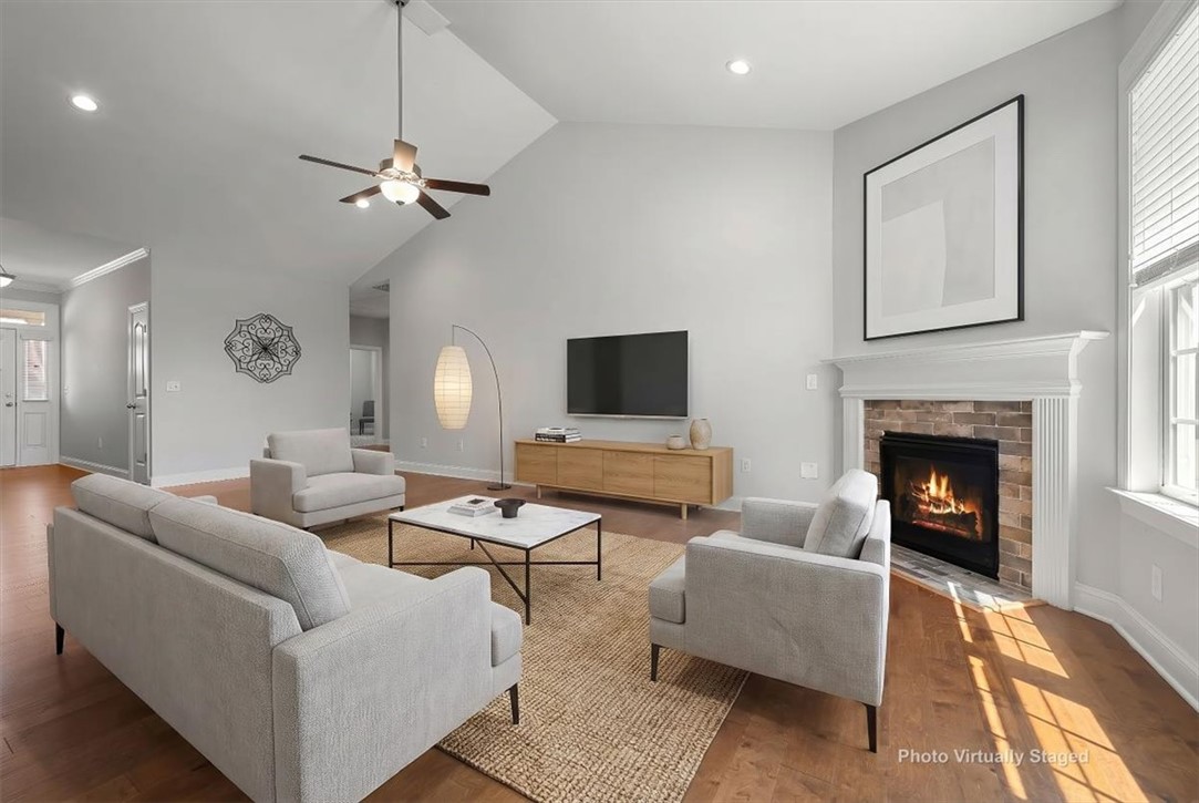 21 Barron Glenn Way Anderson, SC 29621 - Photo 13 of 48 This living room features a fireplace with a mantel, Cathedral Ceilings, and a large window, creating a warm, inviting atmosphere.