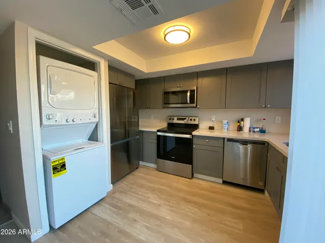 a kitchen with a refrigerator sink and wooden cabinets