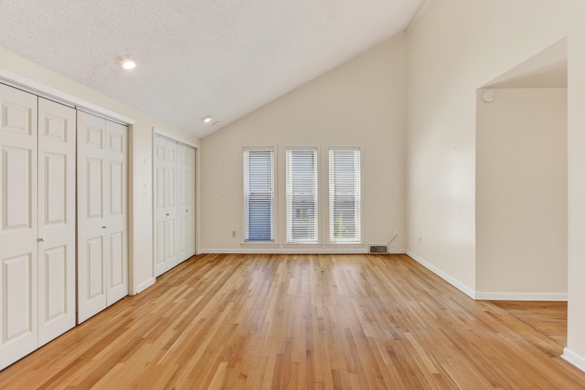 3121 Beechrun Drive Memphis, TN 38128 - Photo 22 of 40 Featuring rich hardwood floors and striking ceilings, this primary bedroom is filled with both warmth and modern character.
