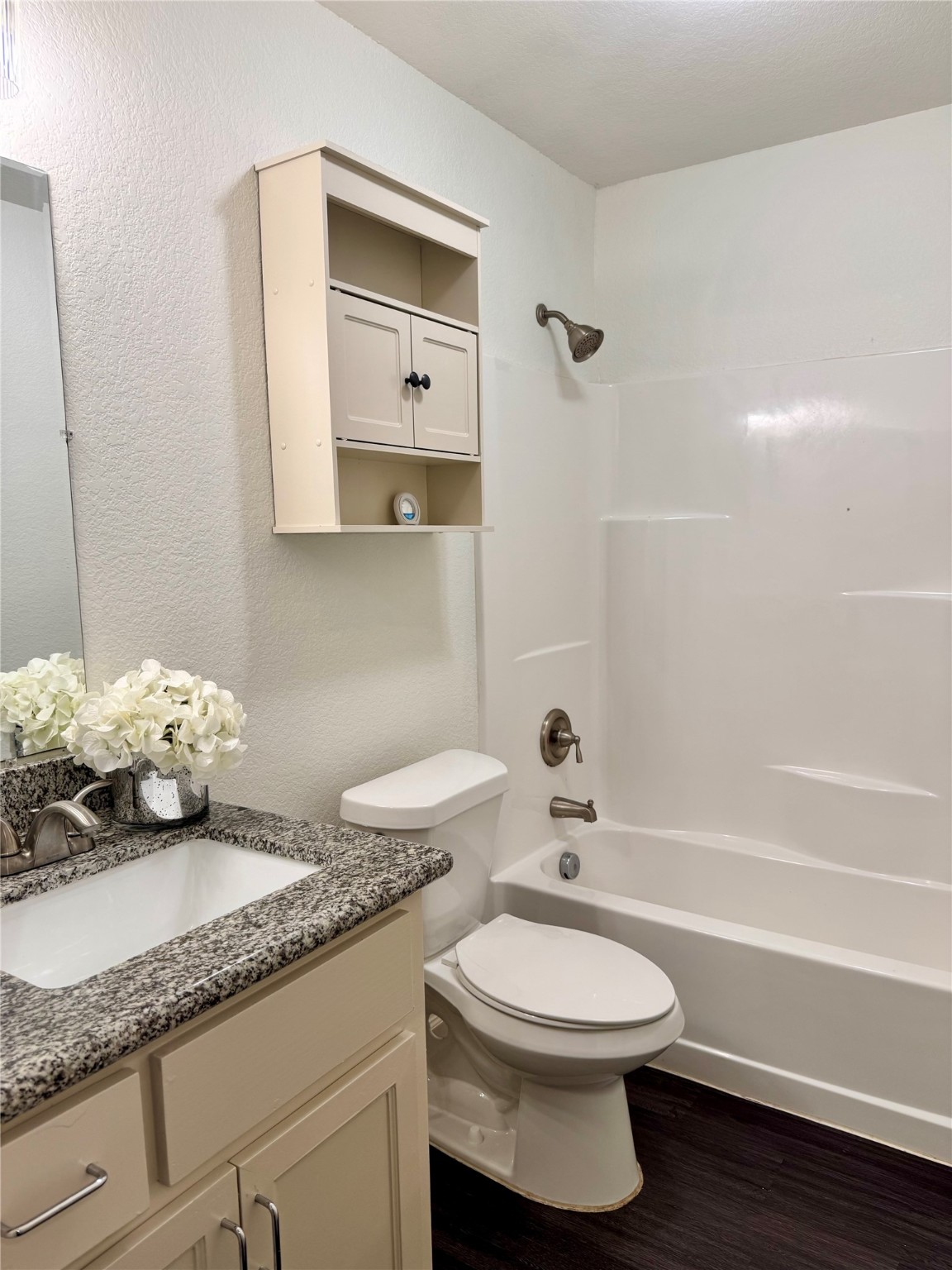 624 Luke Street, Unit A Dayton, TX 77535 - Photo 16 of 20 a bathroom with a granite countertop toilet a sink and a mirror