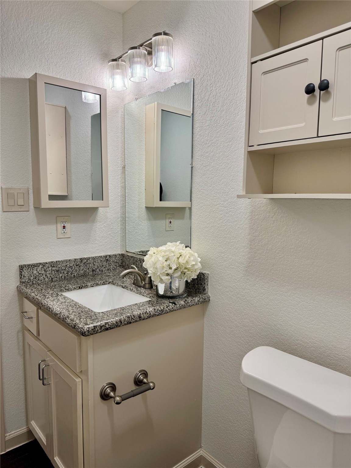 624 Luke Street, Unit A Dayton, TX 77535 - Photo 17 of 20 a bathroom with a granite countertop sink a toilet and mirror