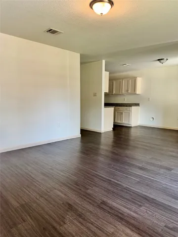 a view of an empty room with wooden floor