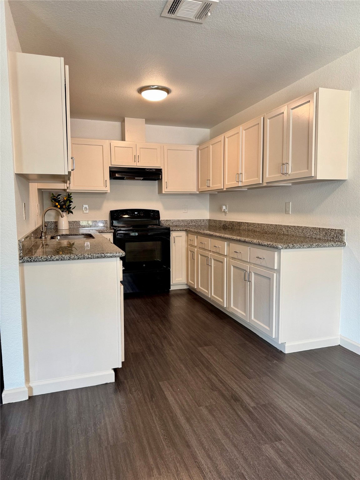 624 Luke Street, Unit A Dayton, TX 77535 - Photo 6 of 20 a kitchen with stainless steel appliances a white stove top oven cabinets and a wooden floor