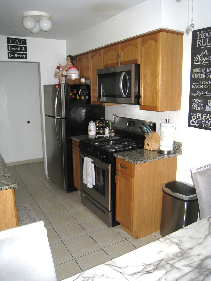 187 Pickwick Drive, Unit 1A Schaumburg, IL 60193 - Photo 2 of 17 a kitchen with stainless steel appliances granite countertop a sink stove and refrigerator