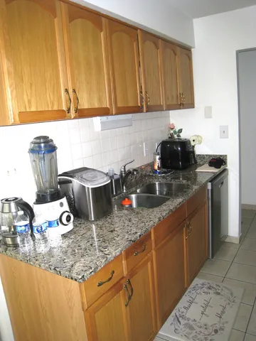a kitchen with kitchen island granite countertop a sink a stove and cabinets