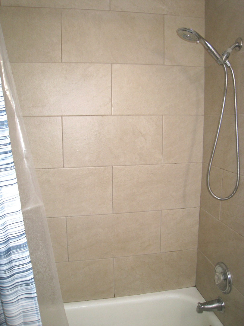 187 Pickwick Drive, Unit 1A Schaumburg, IL 60193 - Photo 8 of 17 a bathroom with a bathtub