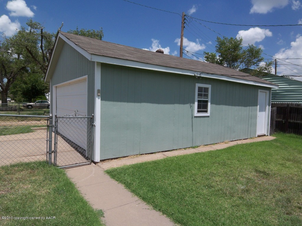 1614 Southwest 48th Avenue Amarillo, TX 79110 - Photo 10 of 13 a view of a backyard with plants and a garage