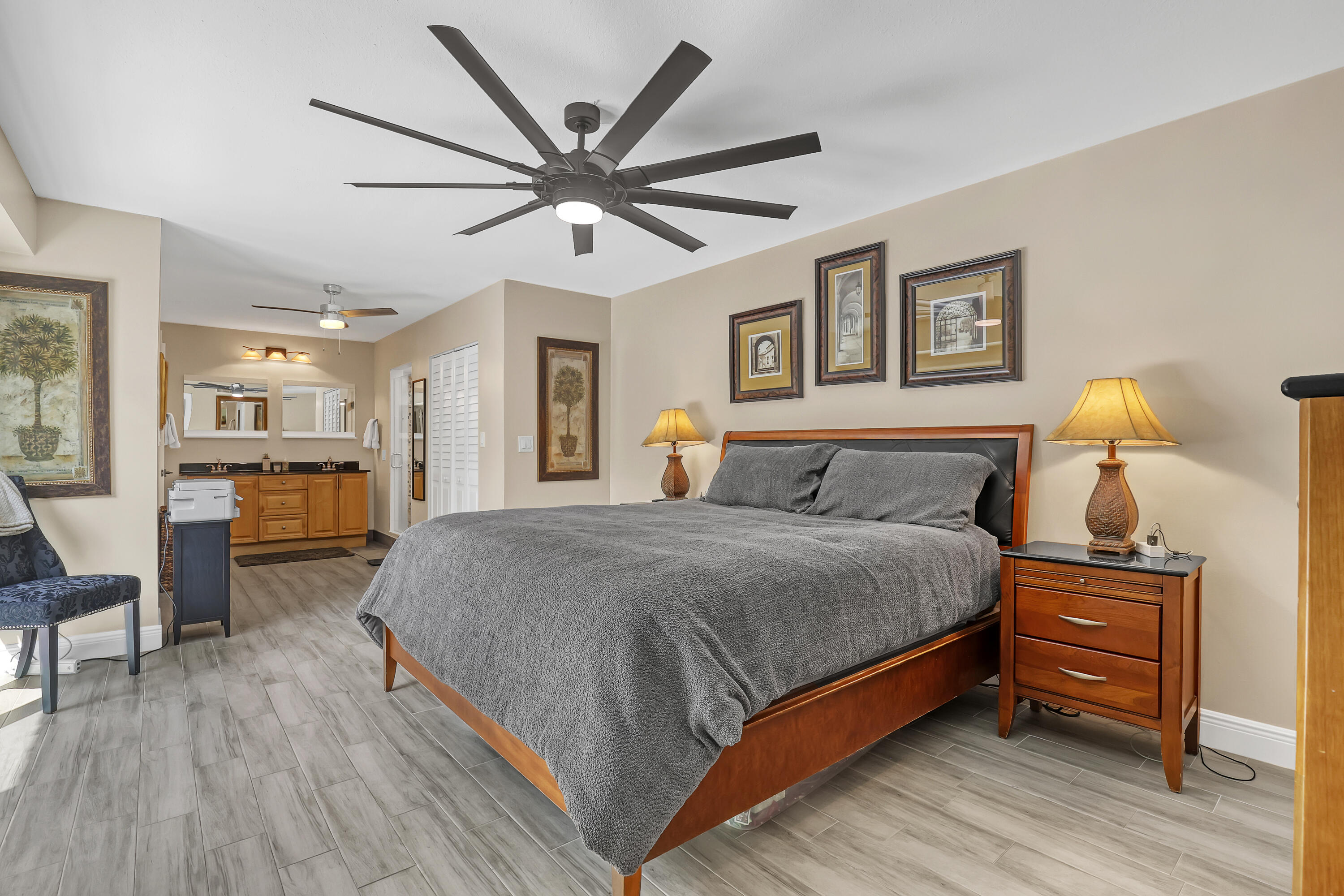 923 Springdale Circle Palm Springs, FL 33461 - Photo 16 of 26 a spacious bedroom with a large bed and a chandelier