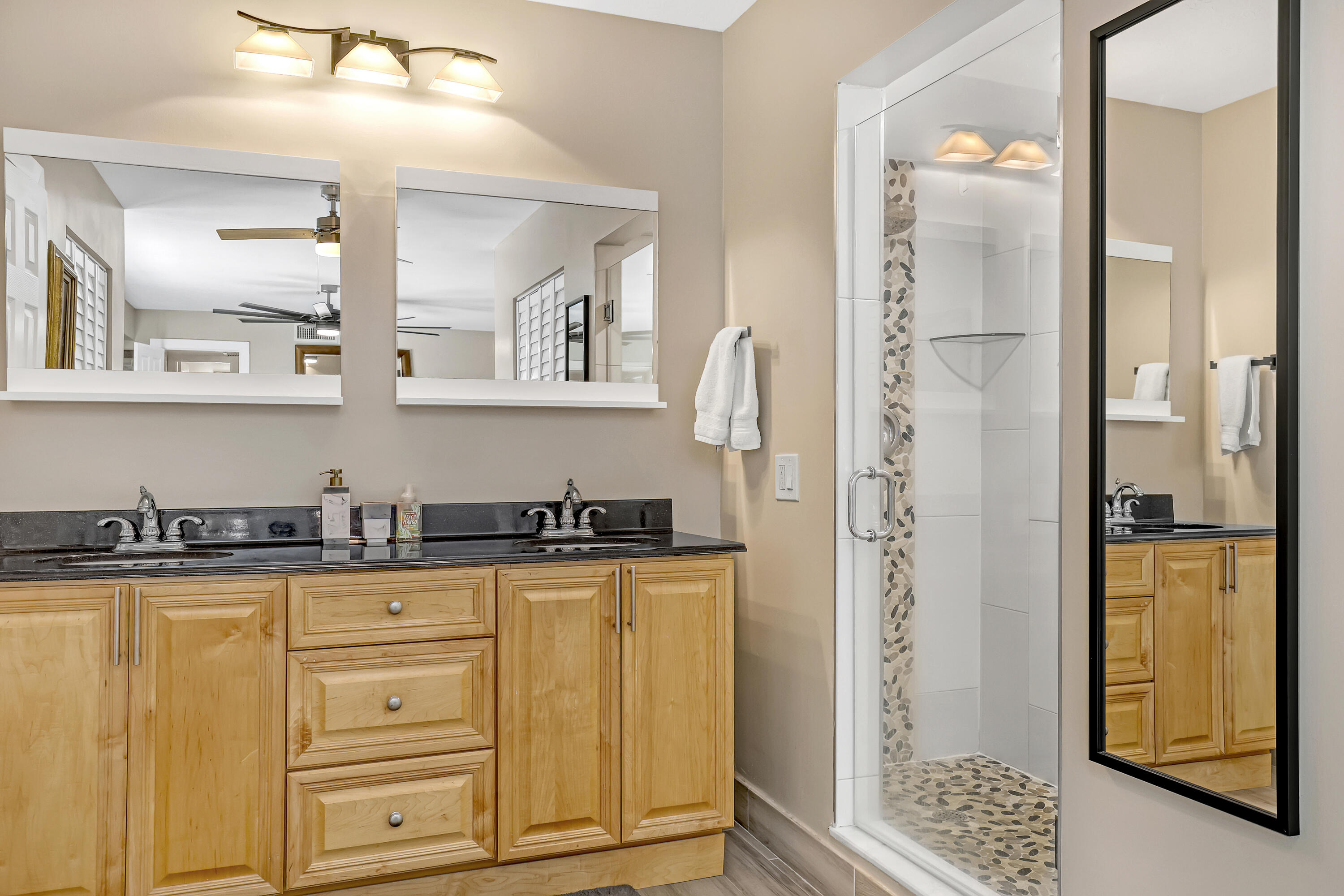 923 Springdale Circle Palm Springs, FL 33461 - Photo 19 of 26 a bathroom with granite countertop a sink a mirror and a shower