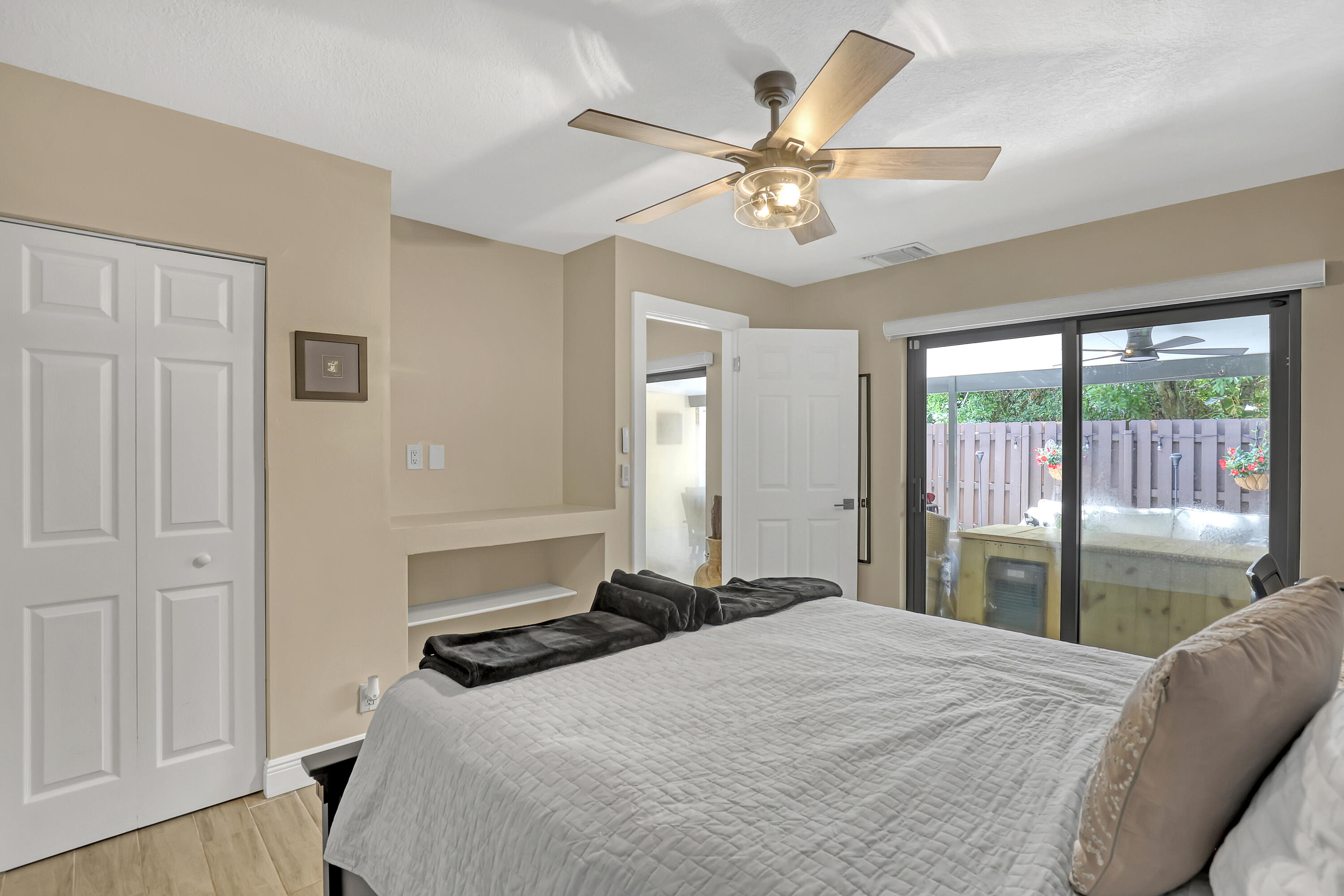 923 Springdale Circle Palm Springs, FL 33461 - Photo 22 of 26 a bedroom with a large bed and a chandelier