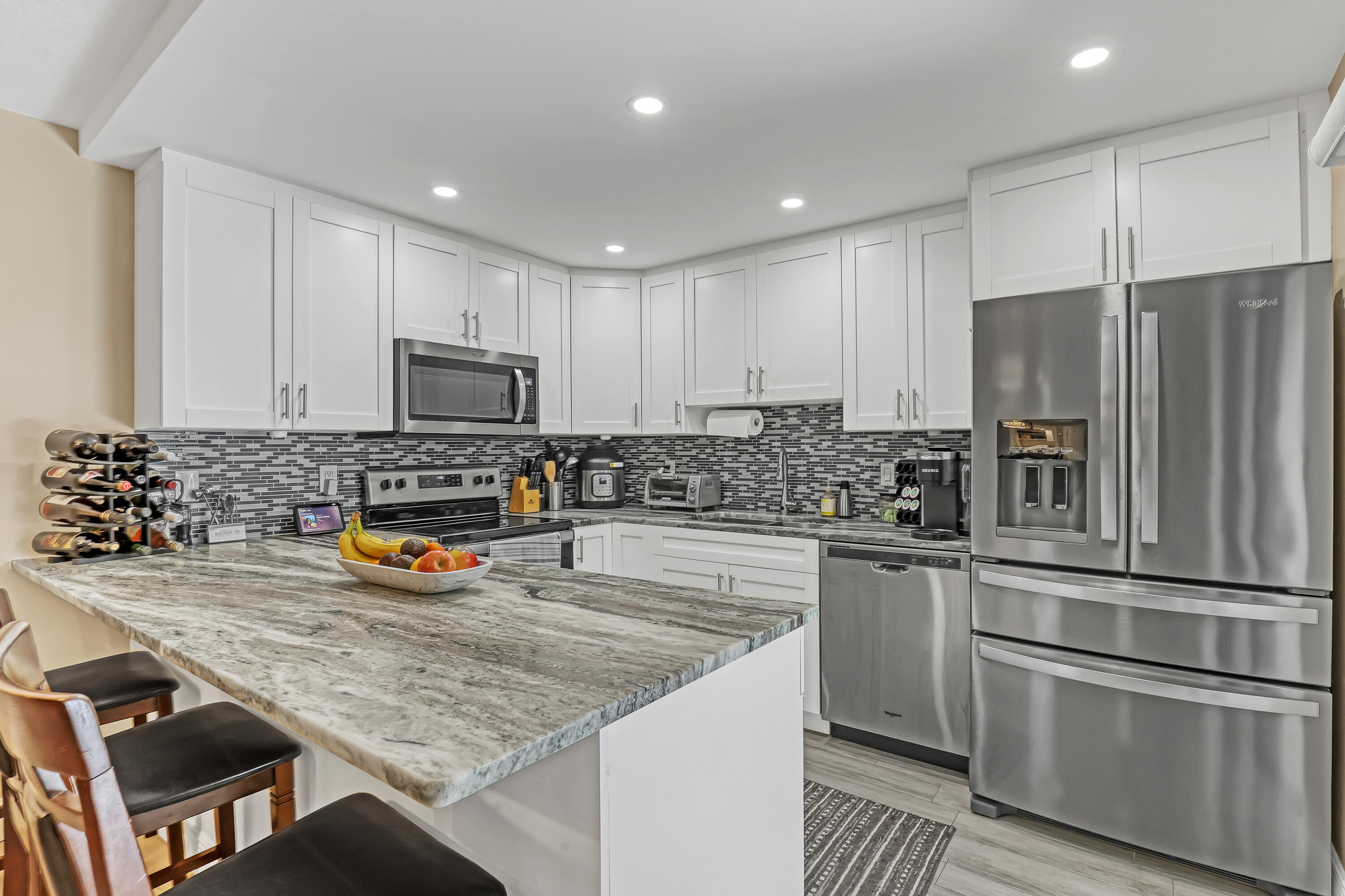 923 Springdale Circle Palm Springs, FL 33461 - Photo 3 of 26 a kitchen with granite countertop stainless steel appliances and wooden cabinets
