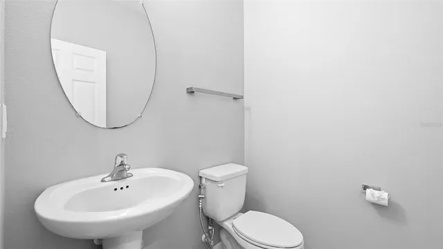 a white toilet sitting next to a white sink