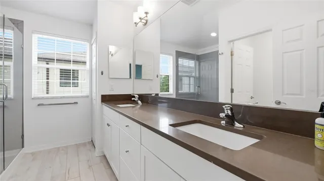 a bathroom with double vanity sinks and a mirror